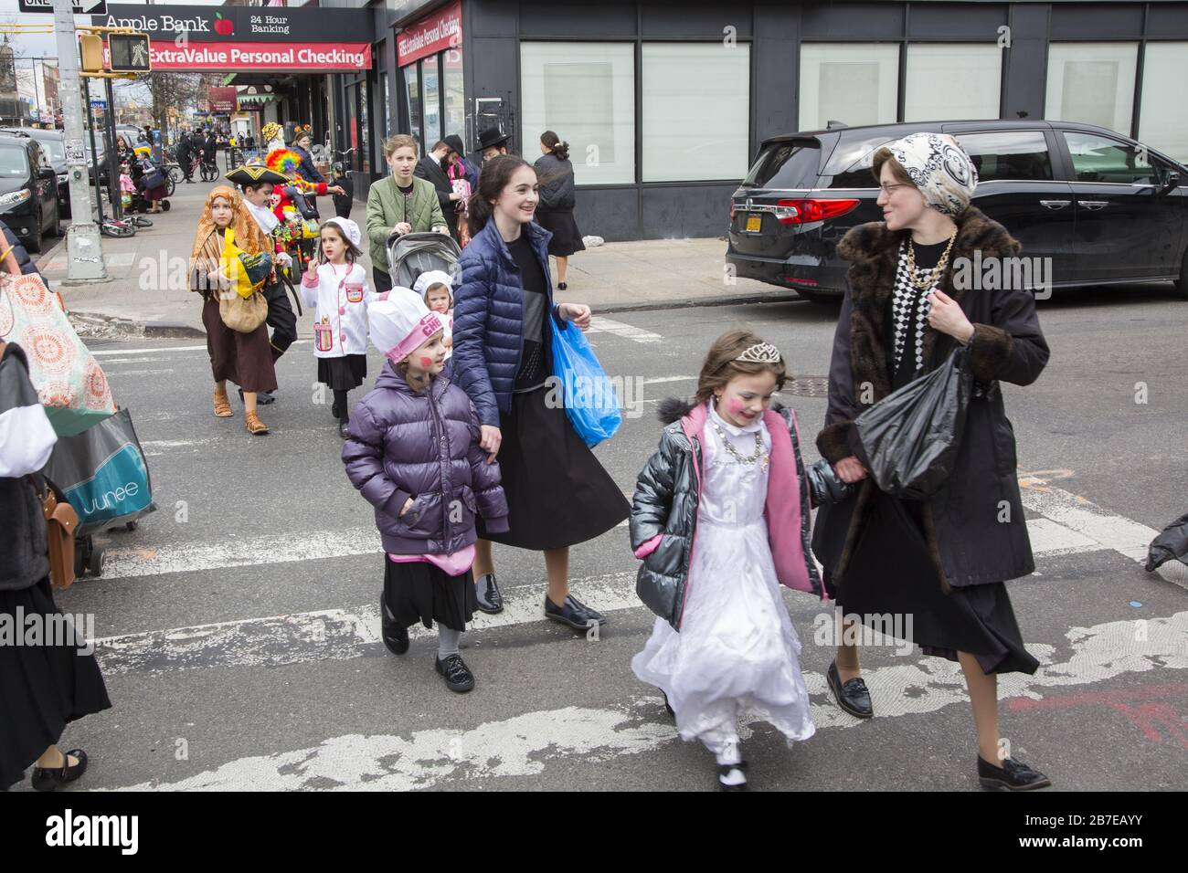 Die orthodoxe jüdische Gemeinde im Borough Park Brooklyn feiert den festlichen Urlaub von Purim, indem sie Kostüme trägt, Armen spendet, leckere Speisen isst und im Allgemeinen eine gute Zeit hat. Die Leute auf der 13th Avenue. Purim wird jedes Jahr am 14. Des hebräischen Monats Adar gefeiert. Es erinnert an die Errettung des jüdischen Volkes im alten Perserreich aus Hamans Handlung "alle Juden, jung und alt, Säuglinge und Frauen, an einem einzigen Tag zu vernichten, zu töten und zu vernichten", wie in der Megillah (Buch Esther) festgehalten. Stockfoto