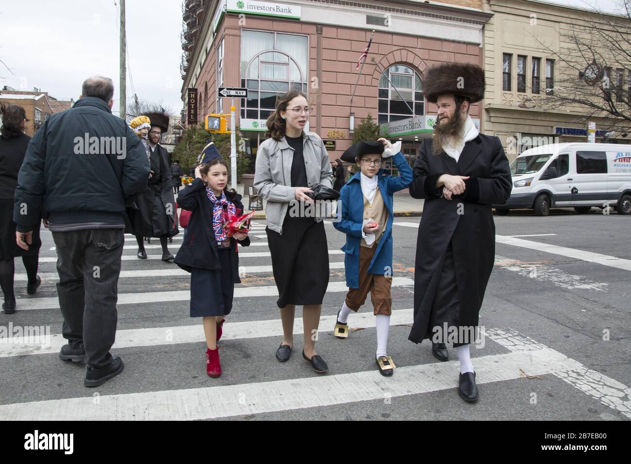 Die orthodoxe jüdische Gemeinde im Borough Park Brooklyn feiert den festlichen Urlaub von Purim, indem sie Kostüme trägt, Armen spendet, leckere Speisen isst und im Allgemeinen eine gute Zeit hat. Die Leute auf der 13th Avenue. Purim wird jedes Jahr am 14. Des hebräischen Monats Adar gefeiert. Es erinnert an die Errettung des jüdischen Volkes im alten Perserreich aus Hamans Handlung "alle Juden, jung und alt, Säuglinge und Frauen, an einem einzigen Tag zu vernichten, zu töten und zu vernichten", wie in der Megillah (Buch Esther) festgehalten. Stockfoto