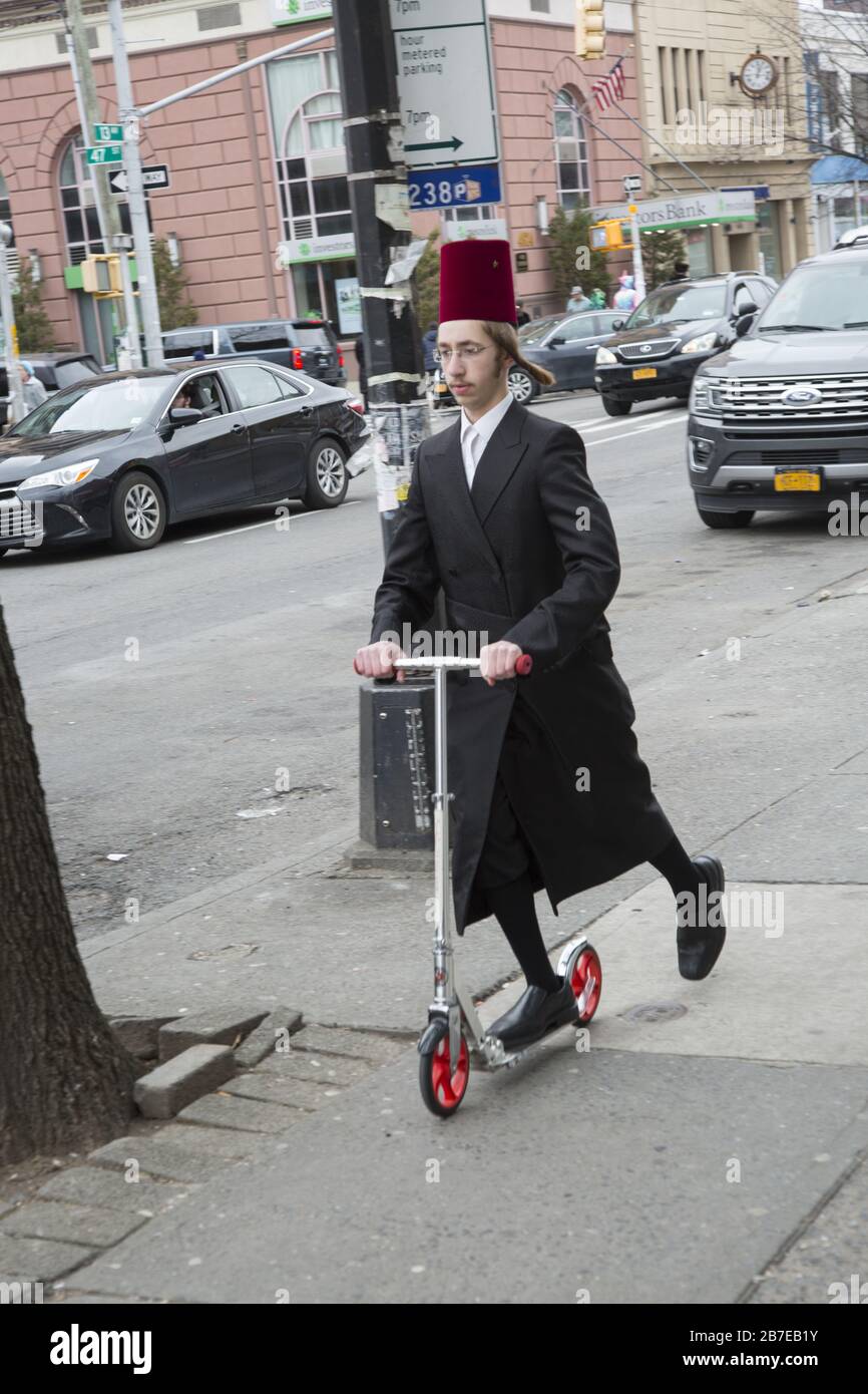 Die orthodoxe jüdische Gemeinde im Borough Park Brooklyn feiert den festlichen Urlaub von Purim, indem sie Kostüme trägt, Armen spendet, leckere Speisen isst und im Allgemeinen eine gute Zeit hat. Die Leute auf der 13th Avenue. Purim wird jedes Jahr am 14. Des hebräischen Monats Adar gefeiert. Es erinnert an die Errettung des jüdischen Volkes im alten Perserreich aus Hamans Handlung "alle Juden, jung und alt, Säuglinge und Frauen, an einem einzigen Tag zu vernichten, zu töten und zu vernichten", wie in der Megillah (Buch Esther) festgehalten. Stockfoto