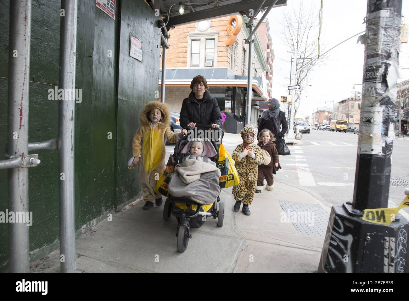 Die orthodoxe jüdische Gemeinde im Borough Park Brooklyn feiert den festlichen Urlaub von Purim, indem sie Kostüme trägt, Armen spendet, leckere Speisen isst und im Allgemeinen eine gute Zeit hat. Die Leute auf der 13th Avenue. Purim wird jedes Jahr am 14. Des hebräischen Monats Adar gefeiert. Es erinnert an die Errettung des jüdischen Volkes im alten Perserreich aus Hamans Handlung "alle Juden, jung und alt, Säuglinge und Frauen, an einem einzigen Tag zu vernichten, zu töten und zu vernichten", wie in der Megillah (Buch Esther) festgehalten. Stockfoto