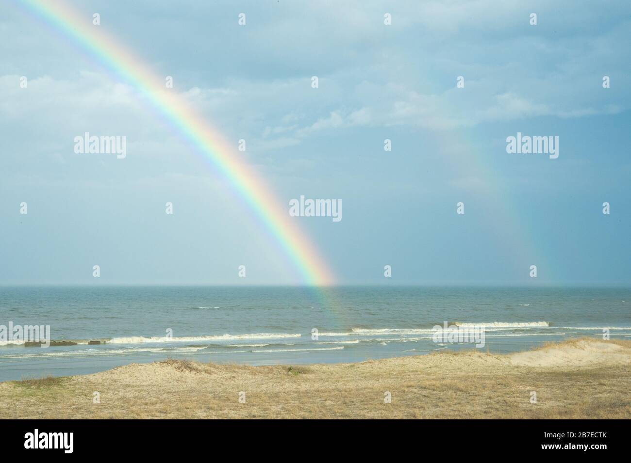 Doppelregenbogen über Meeresstrand Stockfoto