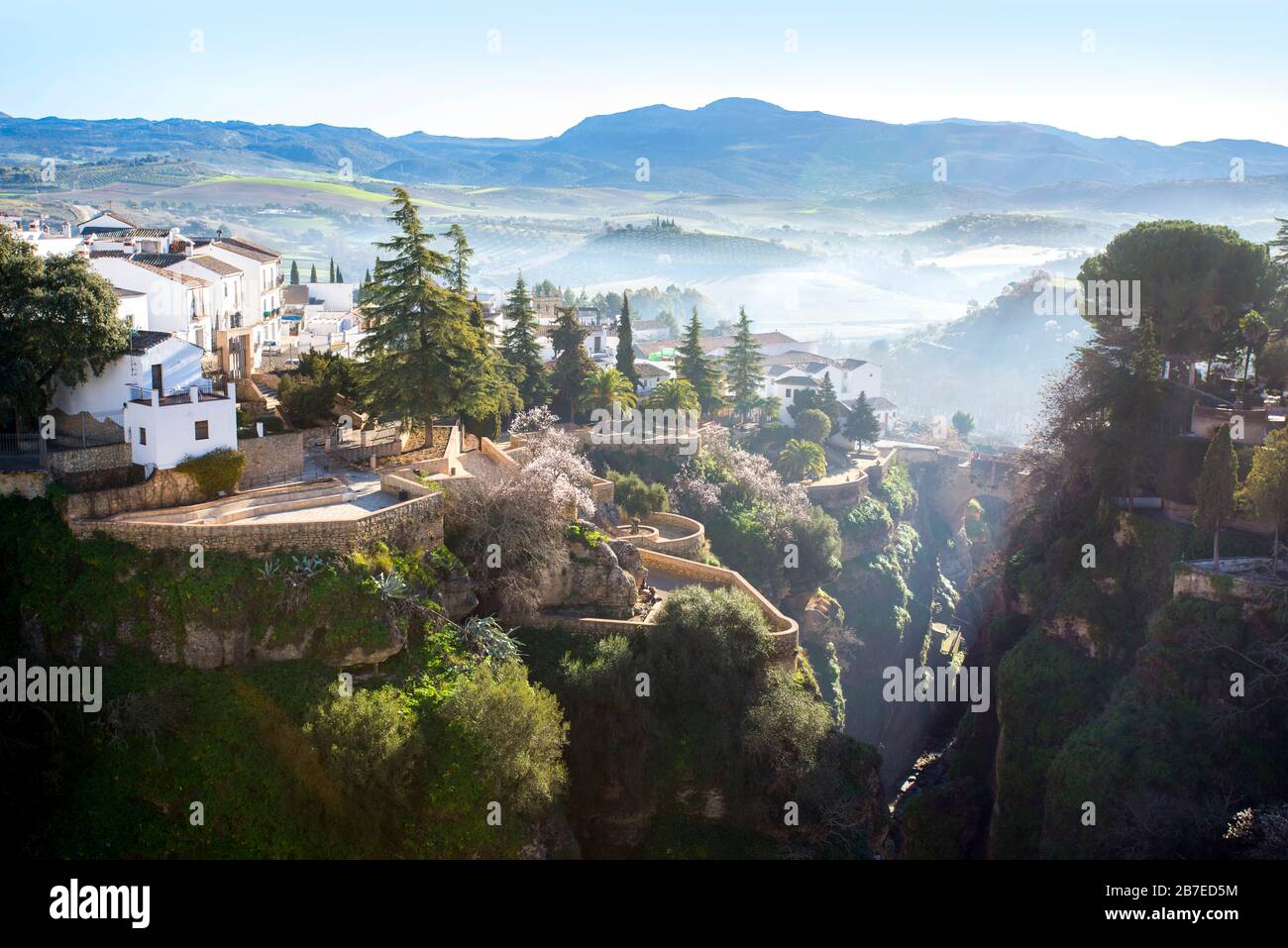 Ronda, Andalucia, Spanien, wo sich der Morgennebel über die spektakuläre Schlucht, die traditionellen weißen Häuser und die fernen Orangenhaine absetzt. Stockfoto