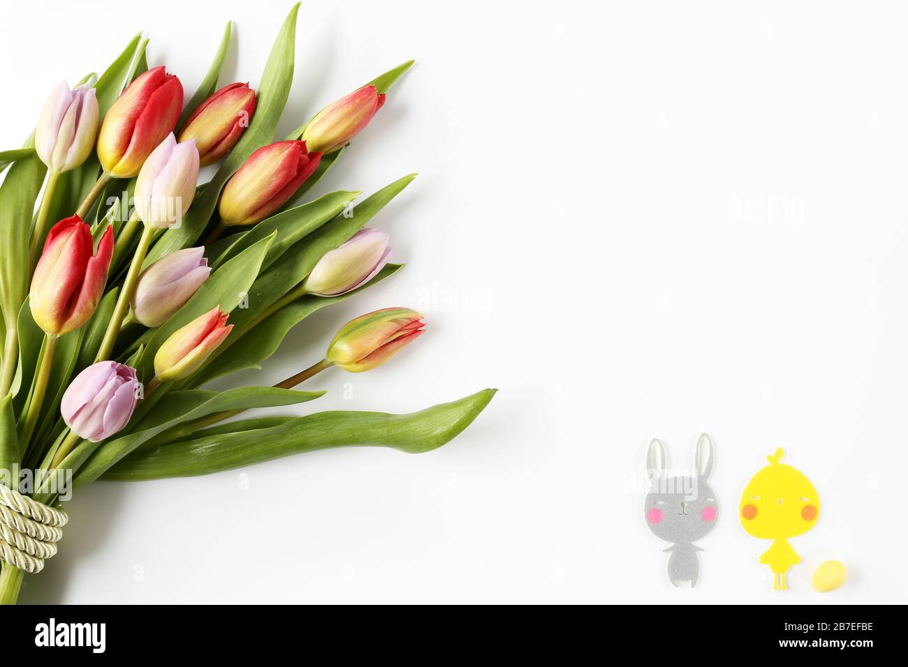 Blumenstrauß aus bunten Tulpen mit grünem Band für Ostern, Feier, Glückwünsche, Grüße, Muttertag Stockfoto
