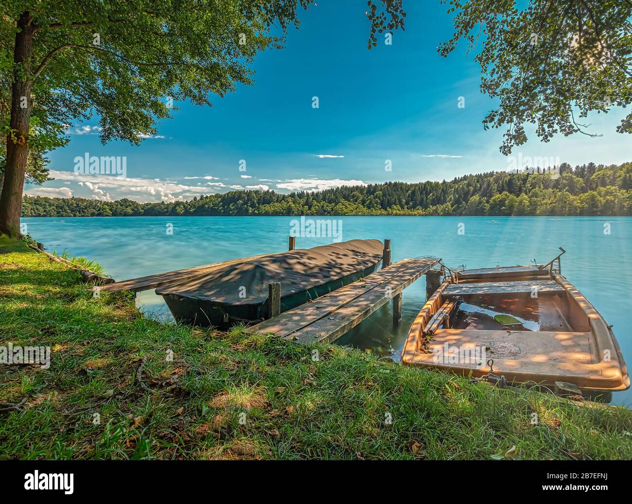 Sommer am See, sonniger Tag mit Blick auf einen zweischiffigen Pier. Stockfoto