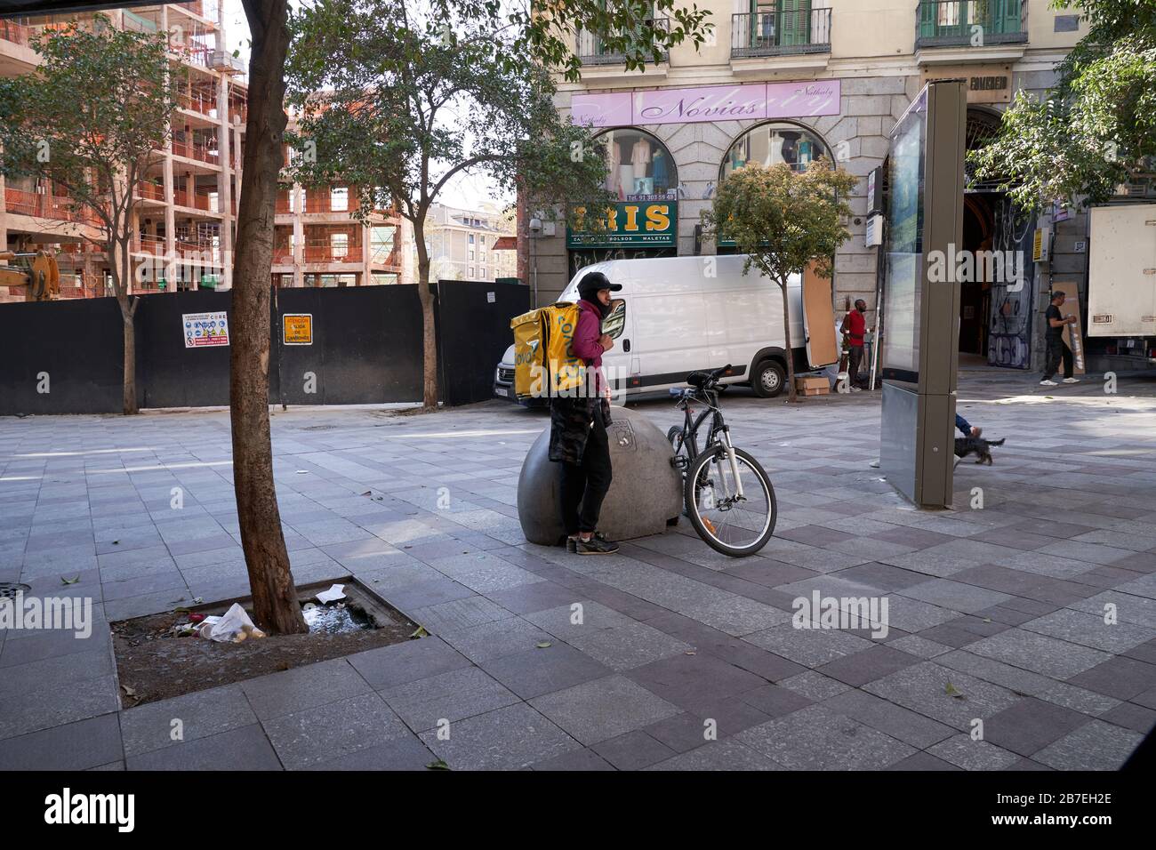 Ein Glovo-Lieferbiker wartet vor einem Laden im Zentrum von Madrid, es sind meist Hundegänger und Auslieferer außerhalb des Ausnahmezustands Stockfoto