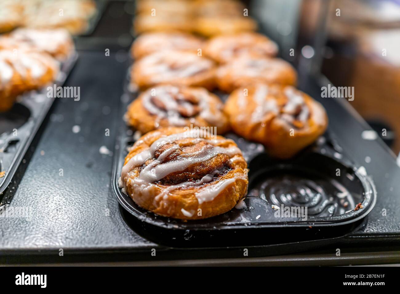 Closeup Makro auf Backwaren Tablet-Buffet für morgens kontinentales Frühstück im Hotel Motel oder Büro für klebrige Zimt-Rollbrötchen mit weißer Vereisung Stockfoto