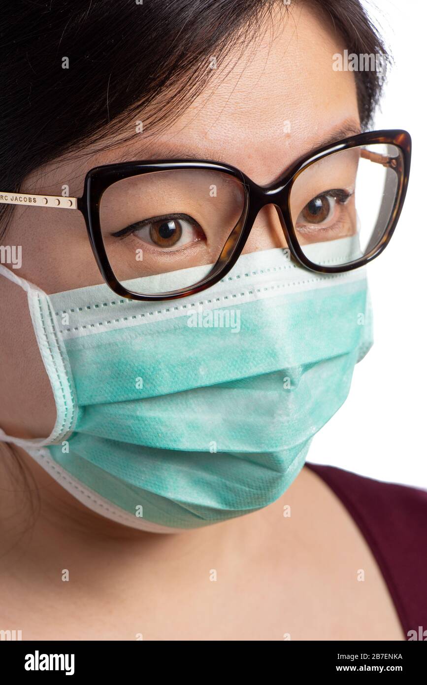 Asian Woman trägt eine Schutzmaske mit Brille auf weißem Hintergrund Stockfoto