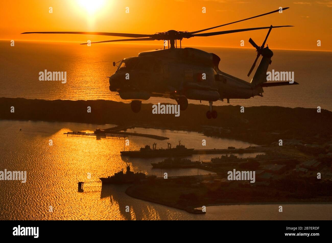 Ein Hubschrauber vom Typ Sikorski S70B Seahawk, der bei Sonnenuntergang über dem Marinestützpunkt von HMAS Stirling in Western Australia fliegt. Stockfoto