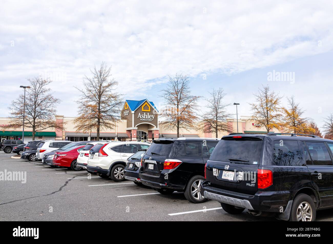 Sterling, USA - 21. November 2019: Ashley Homestore Ladenschild am Eingang des Ladens in Fairfax County, Virginia mit Autos auf dem Parkplatz Stockfoto