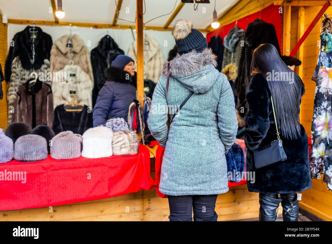 Warschau, Polen - 19. Dezember 2019: Weihnachtsmarkt in der Warszawa-Altstadt mit Menschen, die im Winter beim Fellkleiderhersteller einkaufen und Mäntel verkaufen Stockfoto