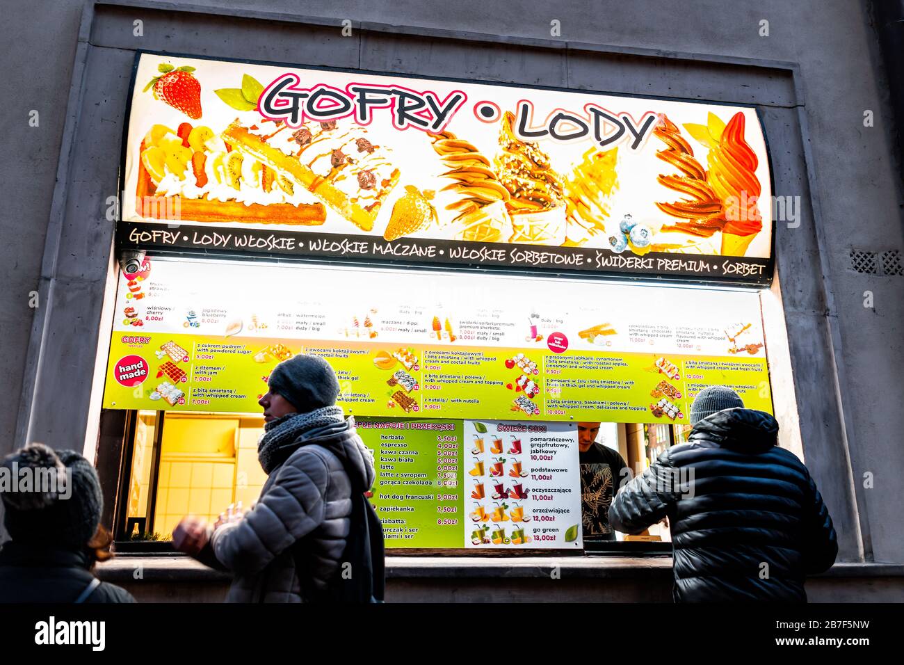 Warschau, Polen - 22. Dezember 2019: Menschen, die im Winter auf dem Warszawa-Marktplatz in der Altstadt für belgische Waffeln Desserts im Windeln stehen Stockfoto