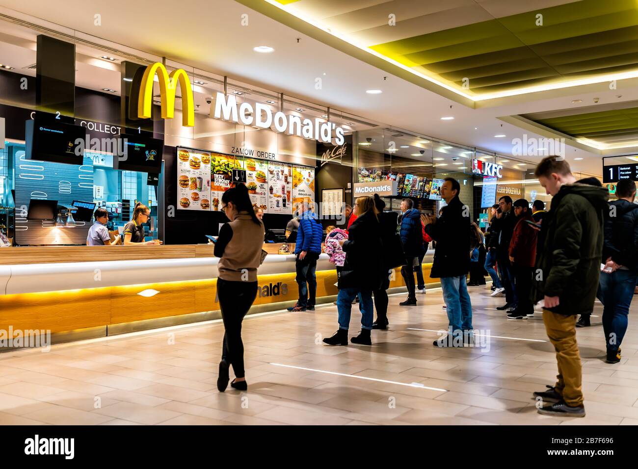 Warschau, Polen - 23. Dezember 2019: Lebensmittelgericht mit Leuten, die in Reihe auf McDonald's und KFC Kentucky Fried Chicken fast Food Chain Rest warten Stockfoto