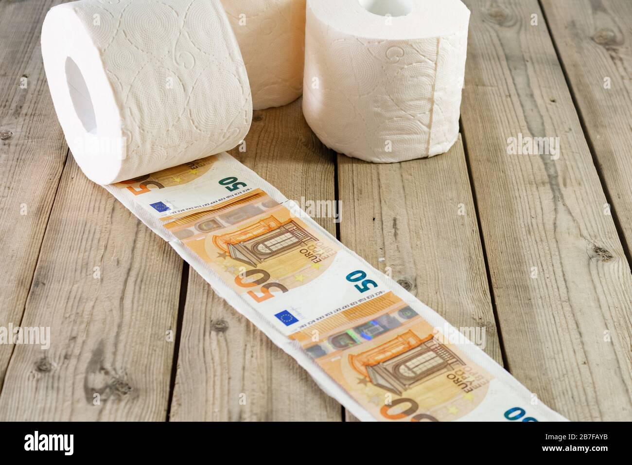 Rolle Toilettenpapier und Euro-Geld, auf Holzgrund. Konzept Stockfotografie  - Alamy