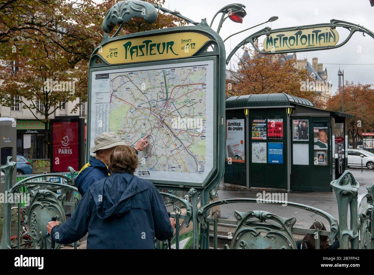 Personen, die eine Karte vor dem Eingang einer Metro-Station in Paris, Frankreich, Europa sehen Stockfoto