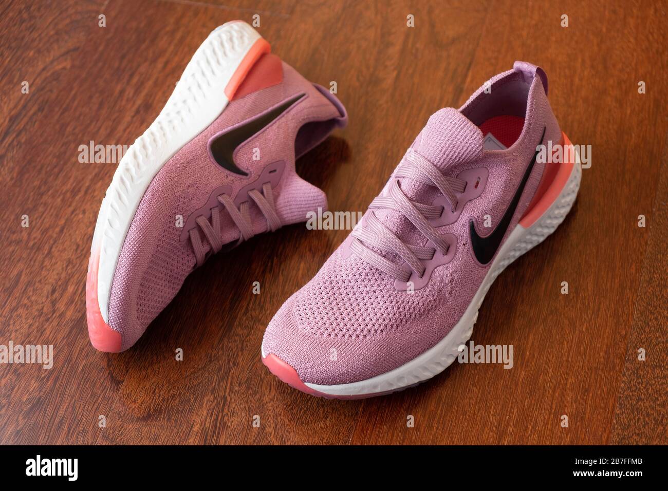 Paar pinke Nike Epic React 2 Laufschuhe auf Hartholzboden Stockfoto