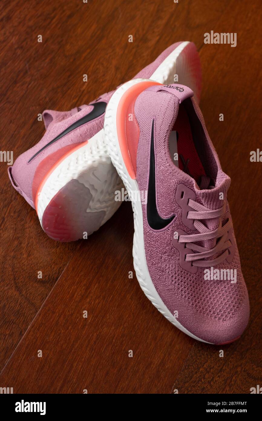 Paar pinke Nike Epic React 2 Laufschuhe auf Hartholzboden Stockfoto