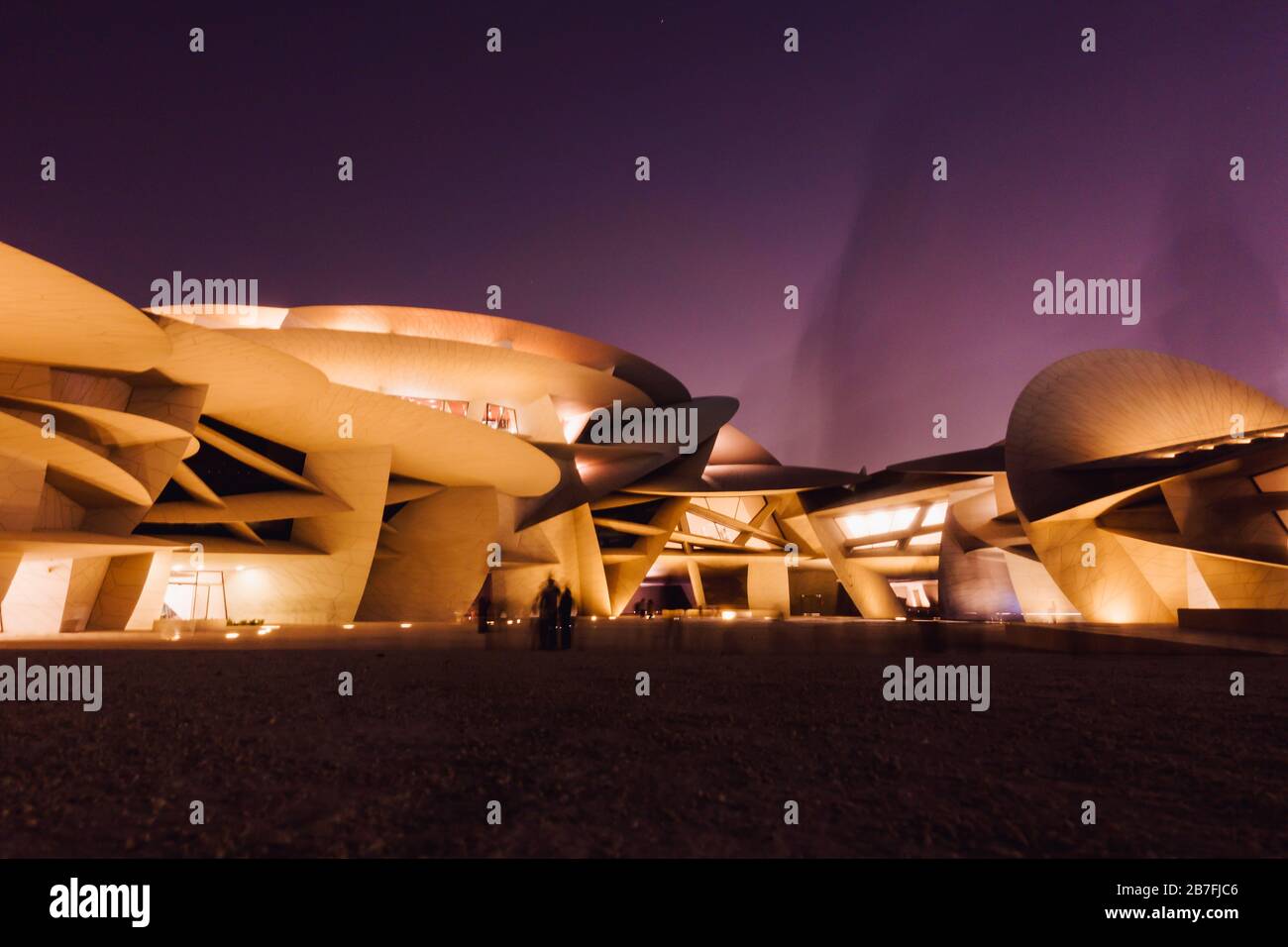 Nachtaufnahme des Nationalmuseums von Katar mit seinem markanten, auf Scheiben basierenden Design in Doha, Katar Stockfoto