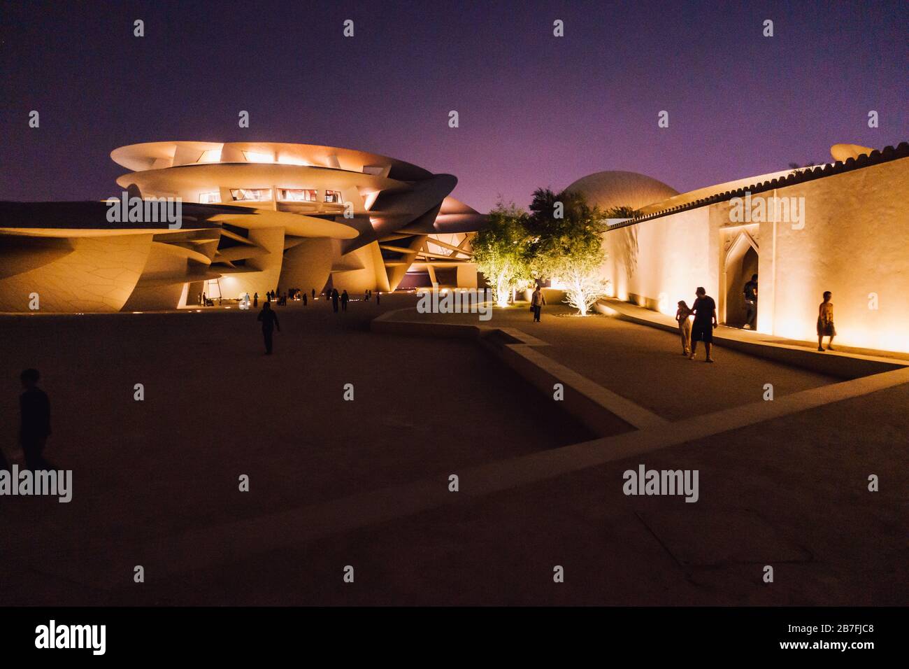 Nachtaufnahme des Nationalmuseums von Katar mit seinem markanten, auf Scheiben basierenden Design in Doha, Katar Stockfoto