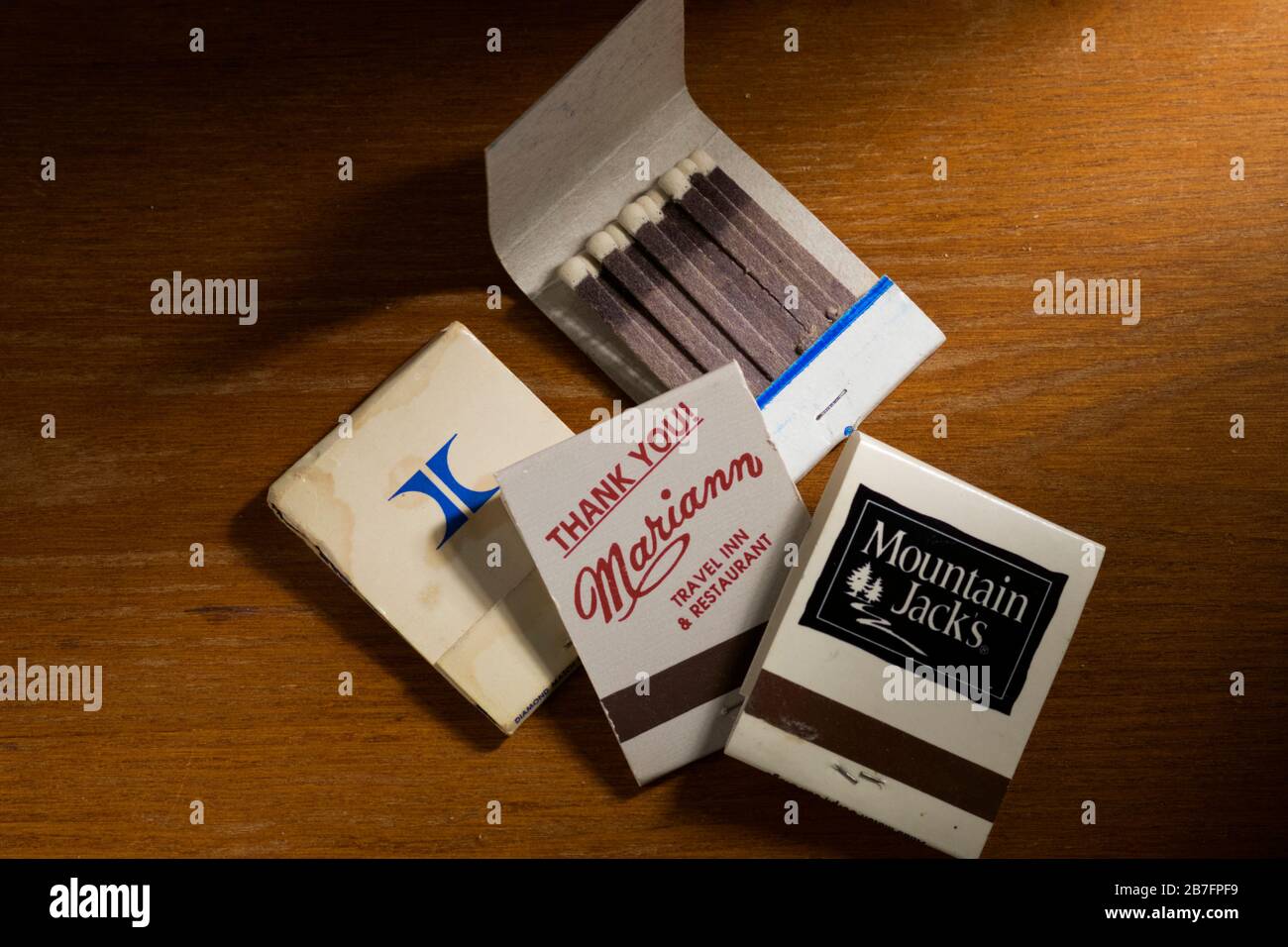 Eine Sammlung von Streichholzbüchern auf einer Holztischplatte. Stockfoto