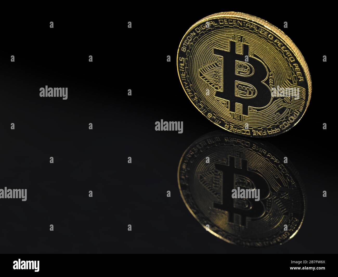 goldene Bitcoin auf schwarzem Hintergrund mit Reflektion und Kopierraum Stockfoto
