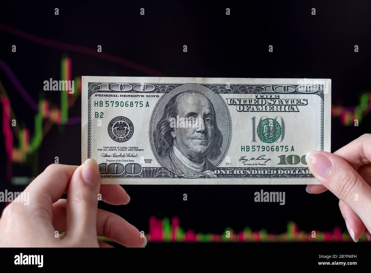 Dollar vor einem Laptop-Monitor mit einem Kursdiagramm.Forex und Trading.EIN Händler handelt Aktien, Anleihen und Wertpapiere oder Währungen auf der Devisenmarke Stockfoto