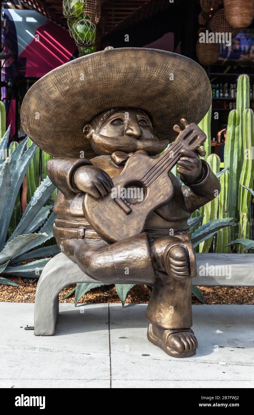 Eine lebensgroße Holzstatue eines Mariachi, das Gitarre spielt und auf einer Bank sitzt, Wynwood Art District, Miami, Florida, USA. Stockfoto