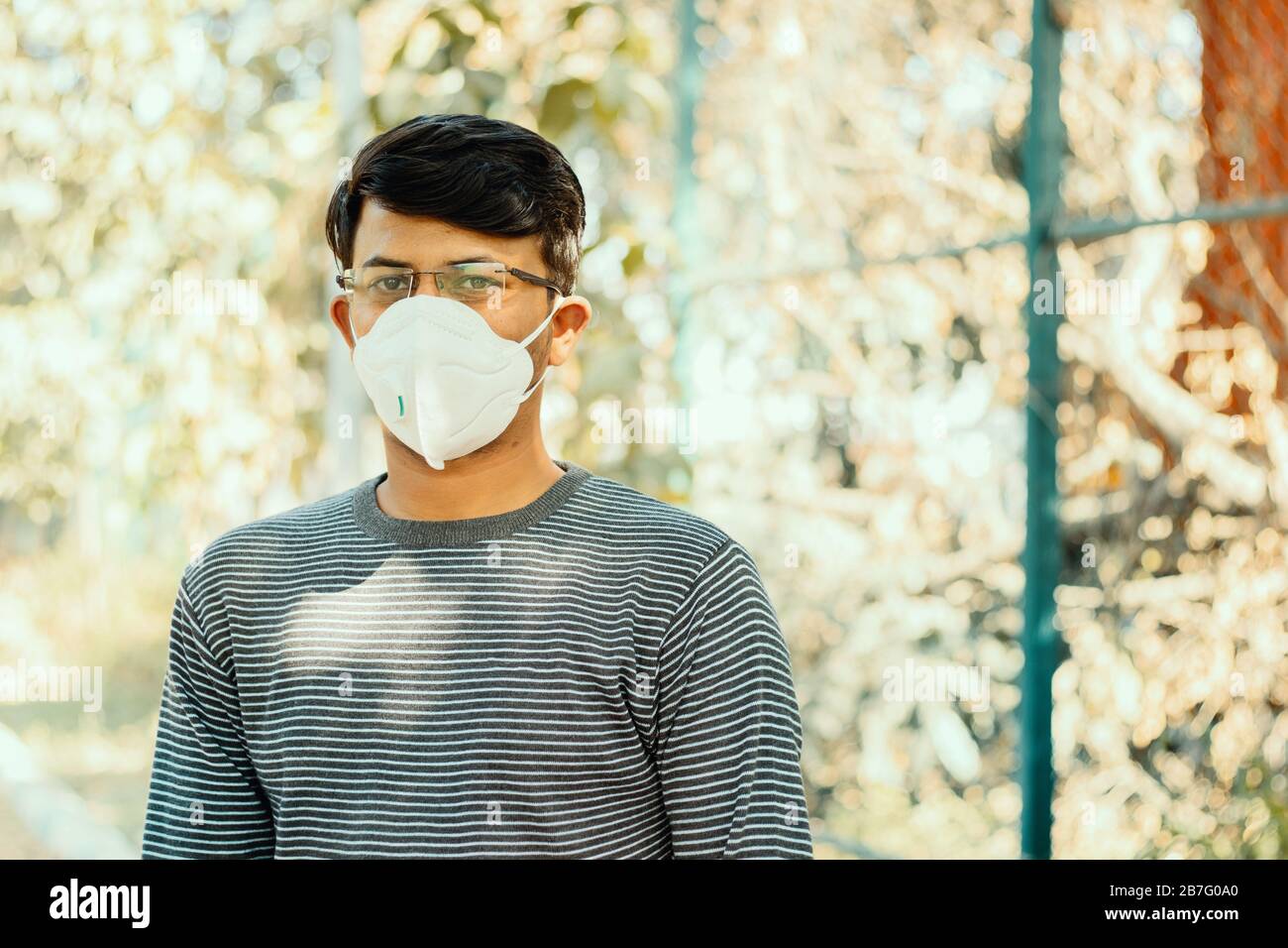 Asiatischer Mann, der die medizinische Gesichtsmaske N95 aufgrund eines Coronavirus- oder Kovid-19-Ausbruchs trägt, im Freien - Person, die vor Luftverschmutzung schützt, Coronavirus Stockfoto