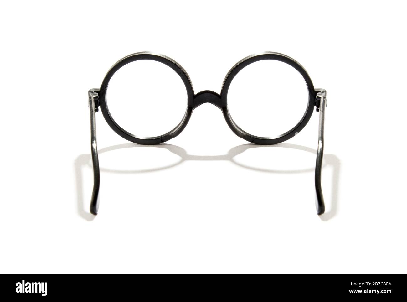 Symmetrischer Blick auf geöffnete Vintage-Brillen mit runden Linsen über weißem Hintergrund mit Schatten- und Kopierraum Stockfoto