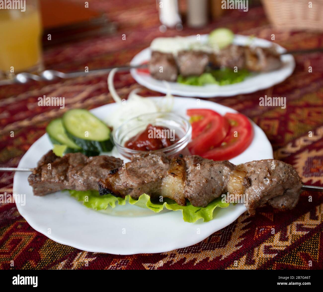 Grillen Sie auf einem Tisch, der mit einem Tischtuch im nationalen Tatarstil bedeckt ist Stockfoto