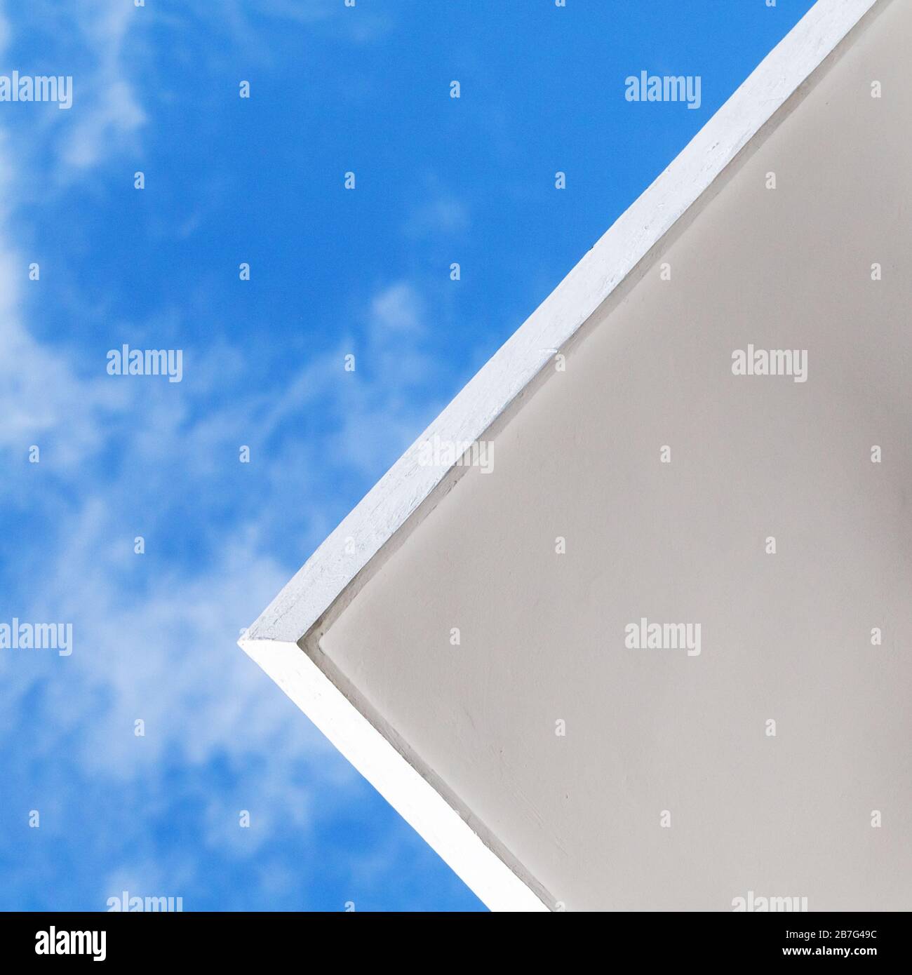 Abstrakter minimaler Architekturhintergrund mit weißer Betondecke unter blauem Himmel, quadratisches Foto Stockfoto
