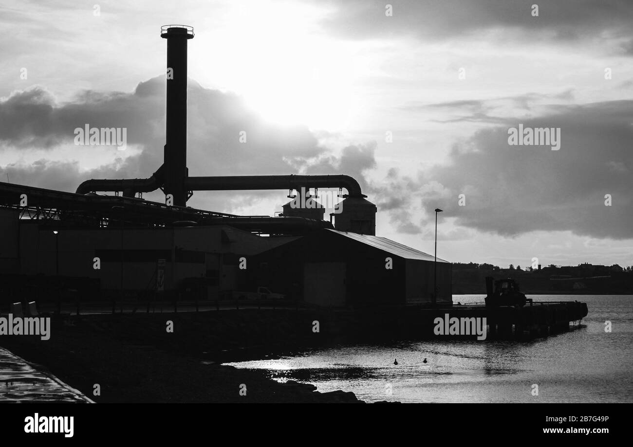 Schwarzes Silhouettenfoto mit einer Industrielandschaft, einer Fabrik auf einer Meeresbrasse in Norwegen Stockfoto