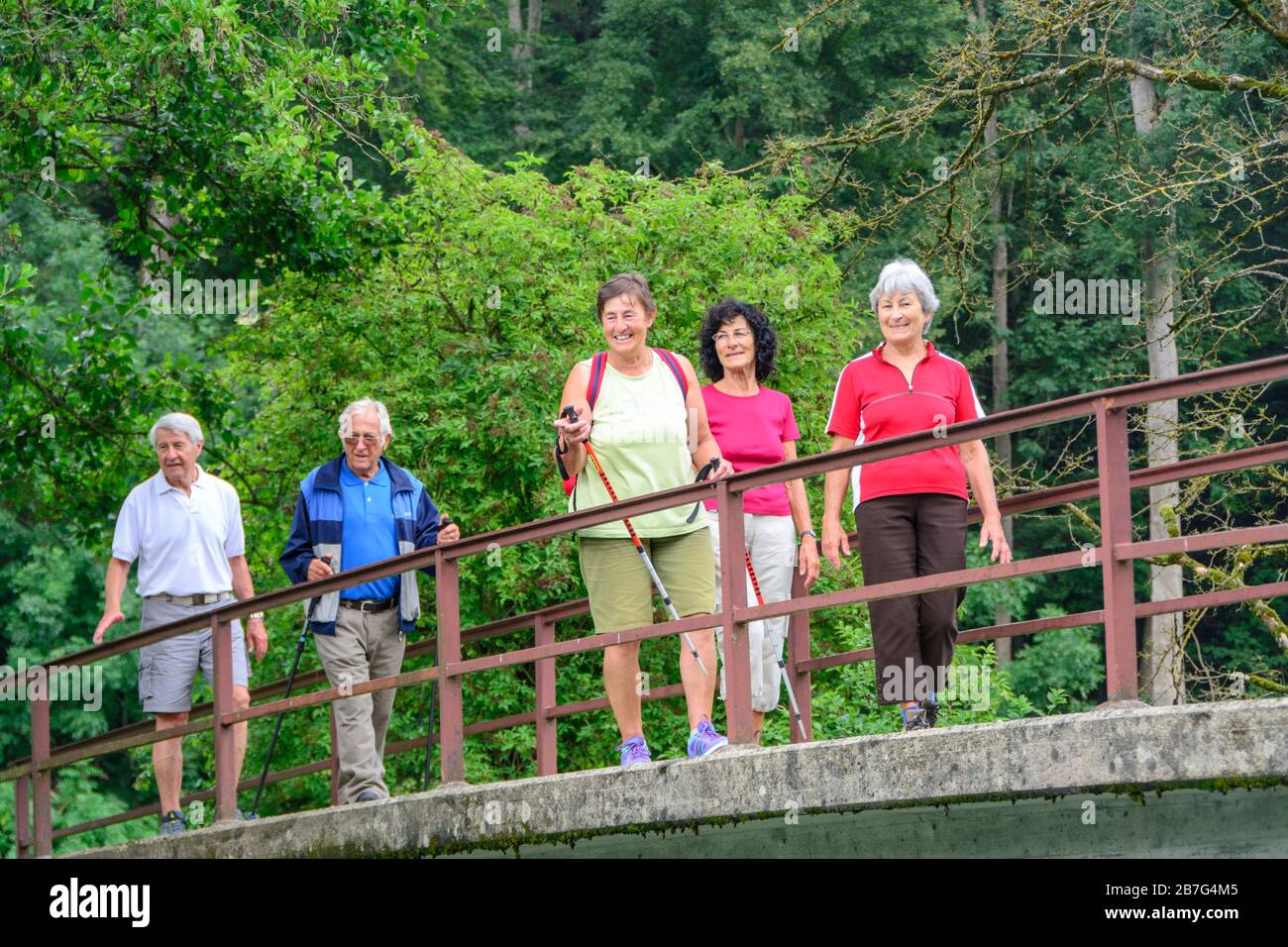 Gut behöhte Senioren wandern in idyllischer Natur Stockfoto