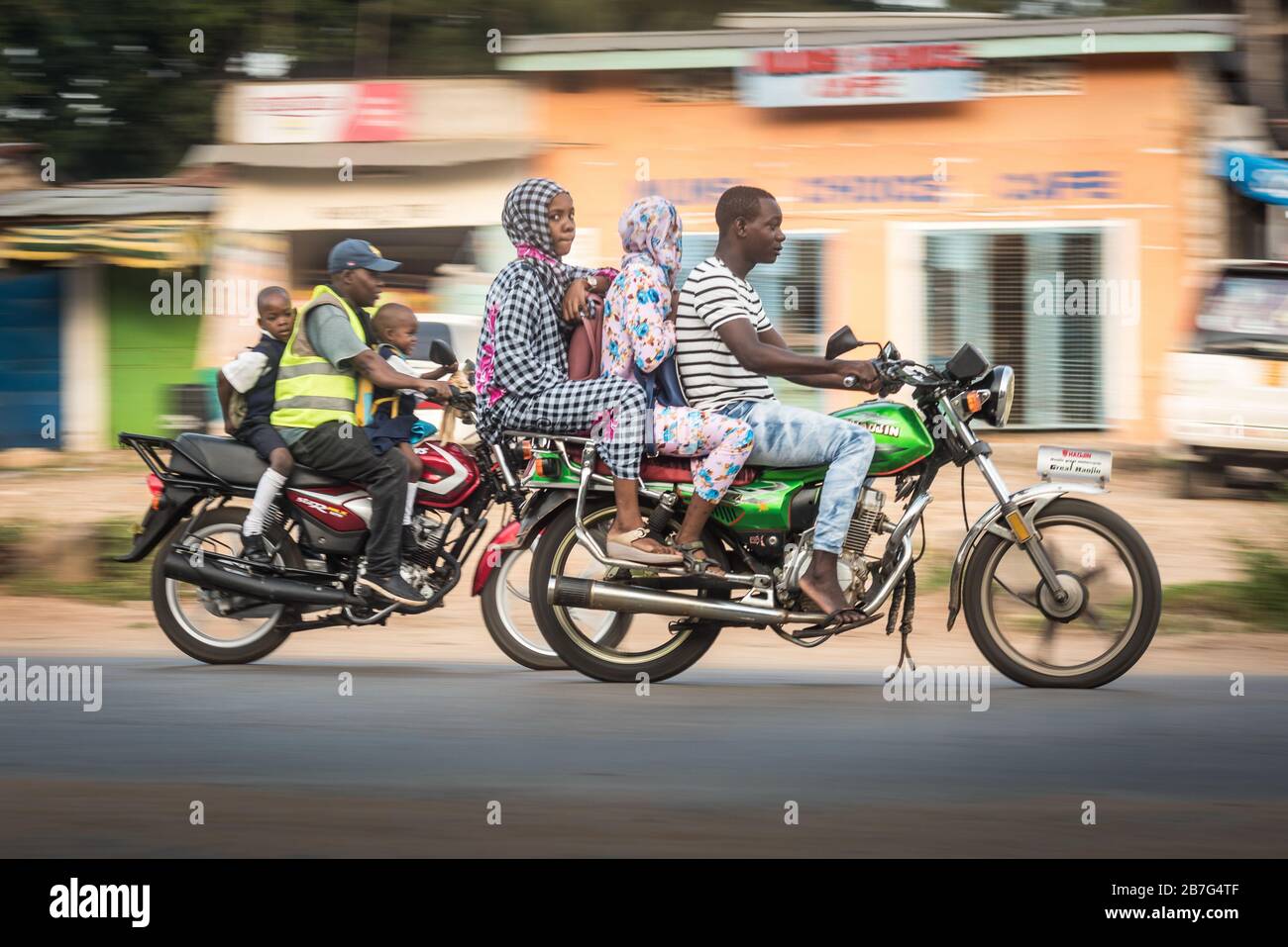 Ukunda / Afrika - 6. März 2020: Motorradverkehr auf den Straßen von Ukunda Kenia Afrika. Schwarze Leute auf den Motorrädern, die Fotos schwenken Stockfoto