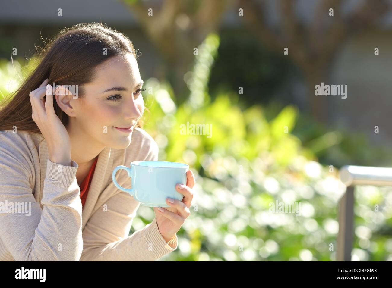 Frau, die sich ausruhen und Kaffee trinken, besinnlichen Blick auf einen Park Stockfoto