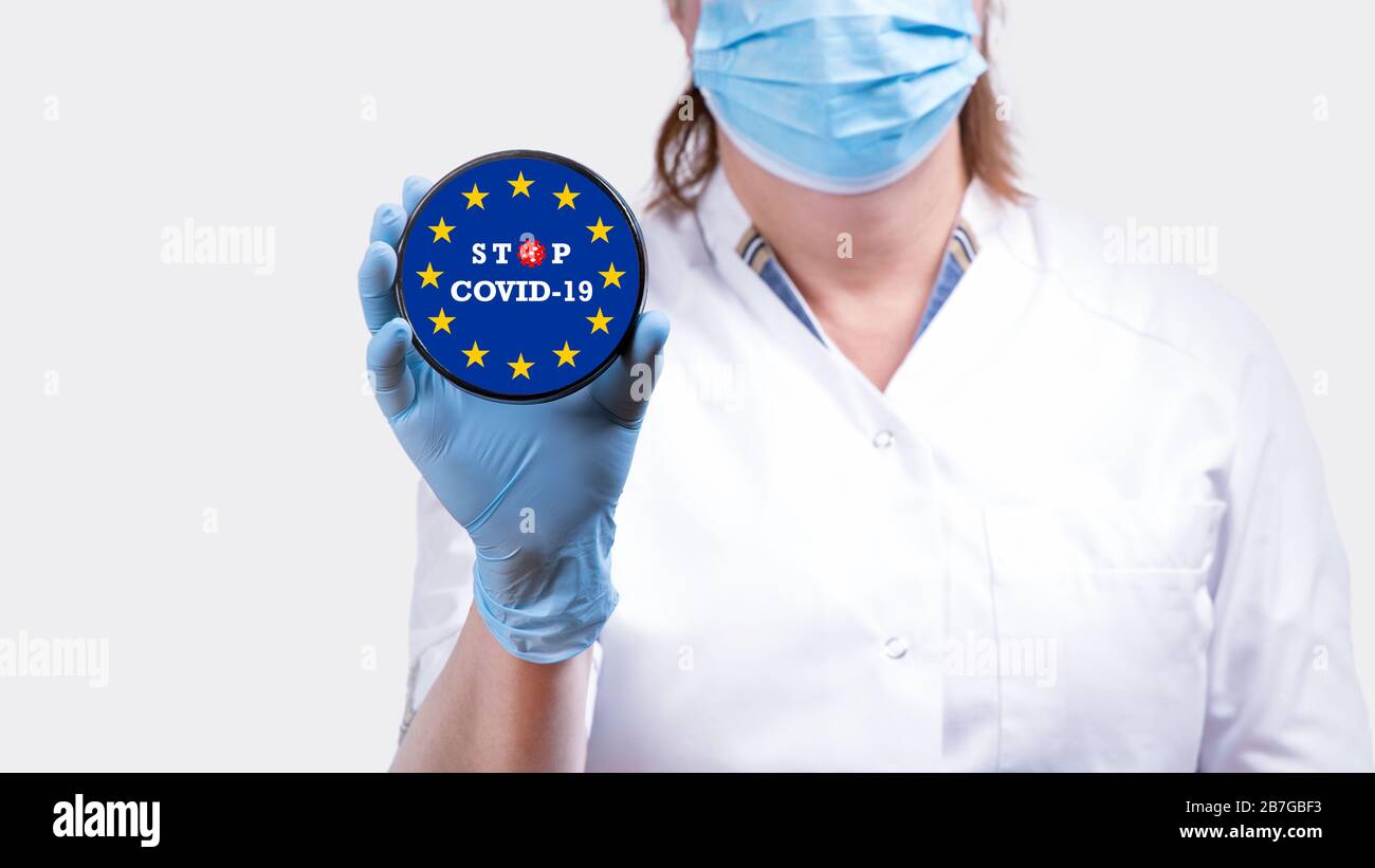 Arzt mit Stoppschild mit Europafild und Text Stop COVID-19 Konzeptbild. Stockfoto