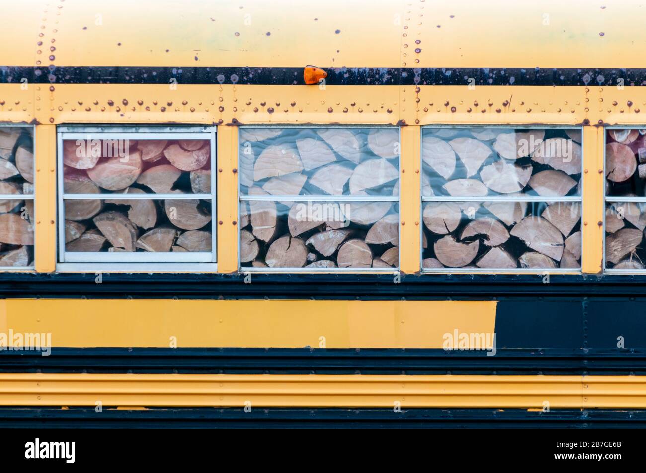 Gehacktes Holz für Brennholz, das in einem alten Schulbus in Neufundland gelagert wird. Stockfoto