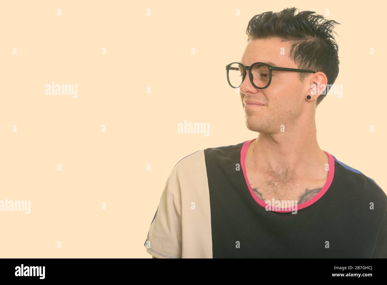 Studio geschossen von geekelt, jungen Mann an der Seite suchen Stockfoto