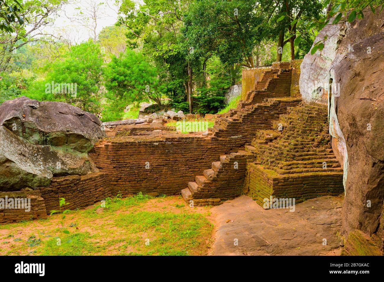 Asien Sri Lanka Sigiriya Rock Fortress & Palace Base Treppe Red Bricks Bäume Felsen entfernt Touristen Stockfoto