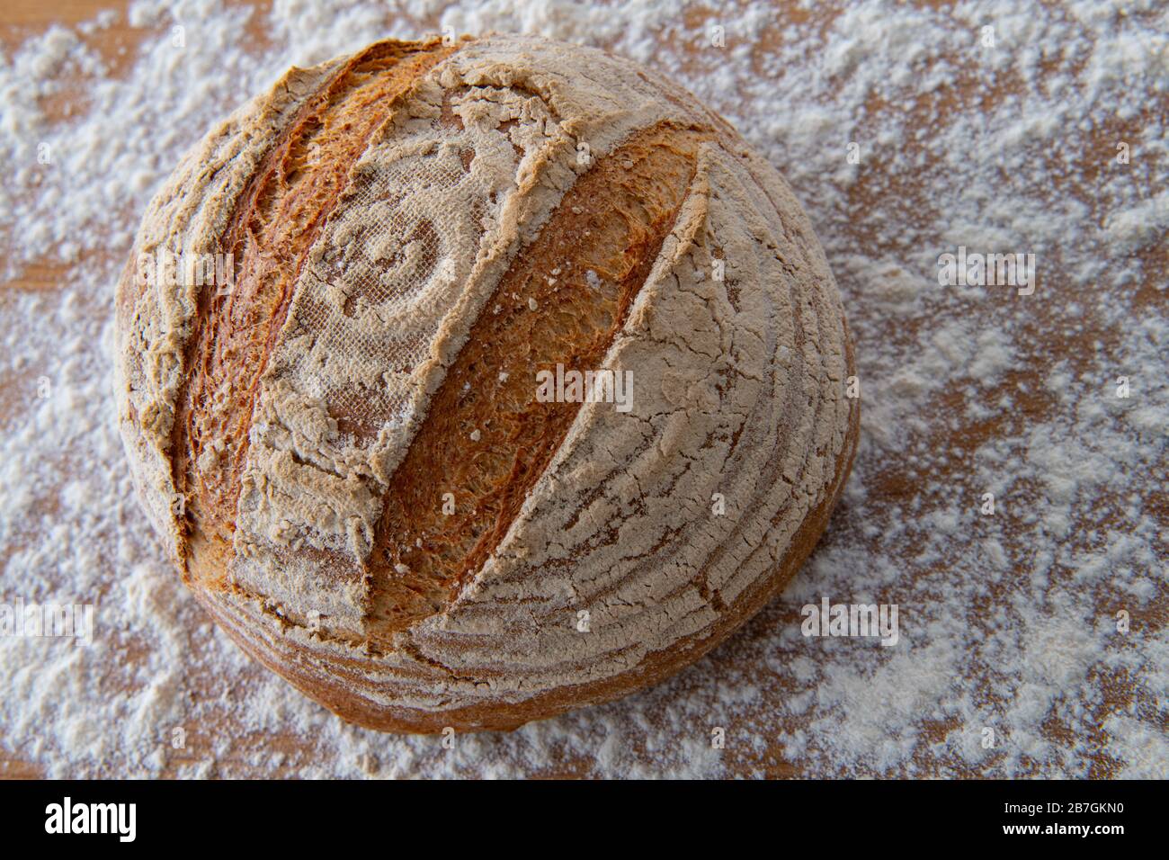 Runden Sie das Brot frisch aus dem Ofen auf einem mit Mehl bedeckten Brett Stockfoto