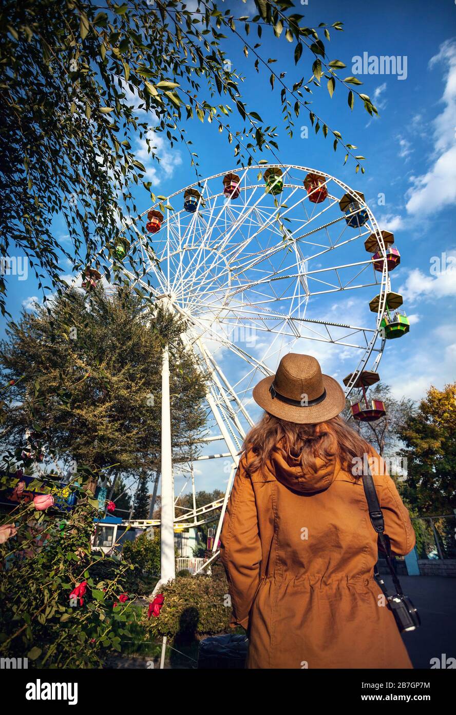Frau mit Hut und Kamera in der Nähe Riesenrad im Herbst Park betrachten Stockfoto