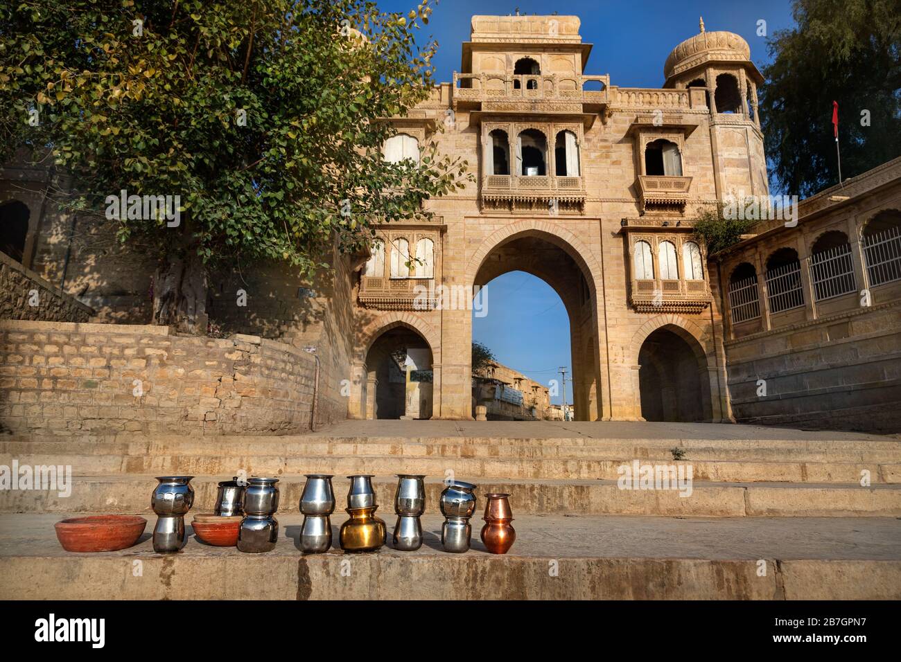 Tempel-Bogen in der Nähe von Gadi Sagar See und rituelle Eisentöpfe in Jaisalmer, Rajasthan, Indien Stockfoto