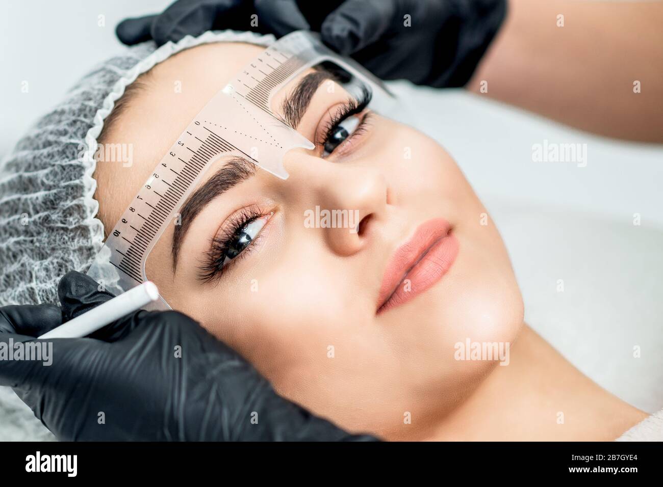 Markup mit Lineal an den Augenbrauen der yong-frau während des permanenten Make-up. Stockfoto