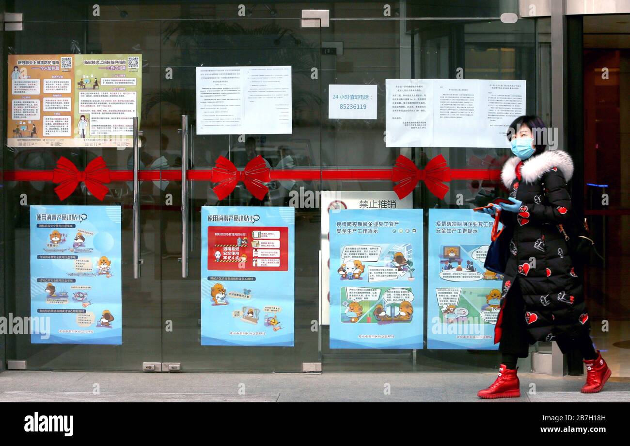 Peking, China. März 2020. Ein chinesischer Arbeiter verlässt am Montag, 16. März 2020, ein Bürogebäude, das mit Gesundheitswarnungen wegen der Bedrohung durch das tödliche Coronavirus (Covid-19) in Peking bedeckt ist. Der Roman Coronavirus hat mehr als 6.500 Menschen getötet. Weltweit gibt es mittlerweile mehr als 152.428 Fälle mit Infektionen in mehr als 144 Ländern auf allen Kontinenten, außer Antatica. Foto von Stephen Shaver/UPI Credit: UPI/Alamy Live News Stockfoto