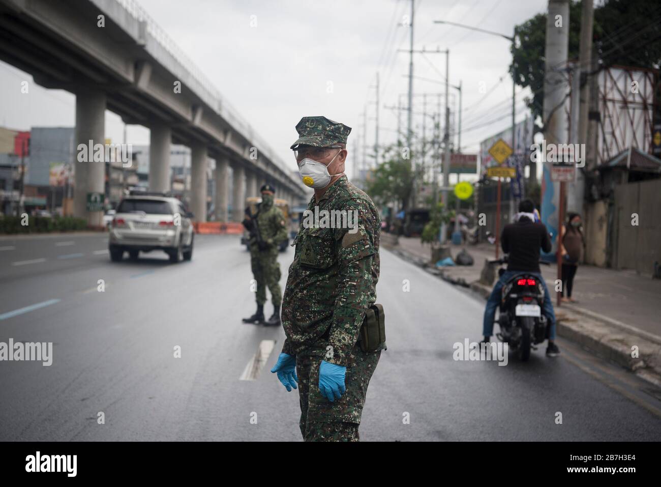 Metro Manila, Philippinen. März 2020. Ein Militäroffizier trägt eine Schutzmaske, während er den eingehenden Verkehr an einem Kontrollpunkt inmitten der Befürchtungen von Coronavirus in Metro Manila überwacht. Die Regierung hat 12 Millionen Menschen in der philippinischen Hauptstadt auf Schloss-down gestellt, während COVID-19 sich weiter verbreitet. Das Gesundheitsministerium der Philippinen hat 140 Fälle des tödlichen Coronavirus im Land bestätigt, darunter 11 aufgezeichnete Todesfälle. Credit: SOPA Images Limited/Alamy Live News Stockfoto