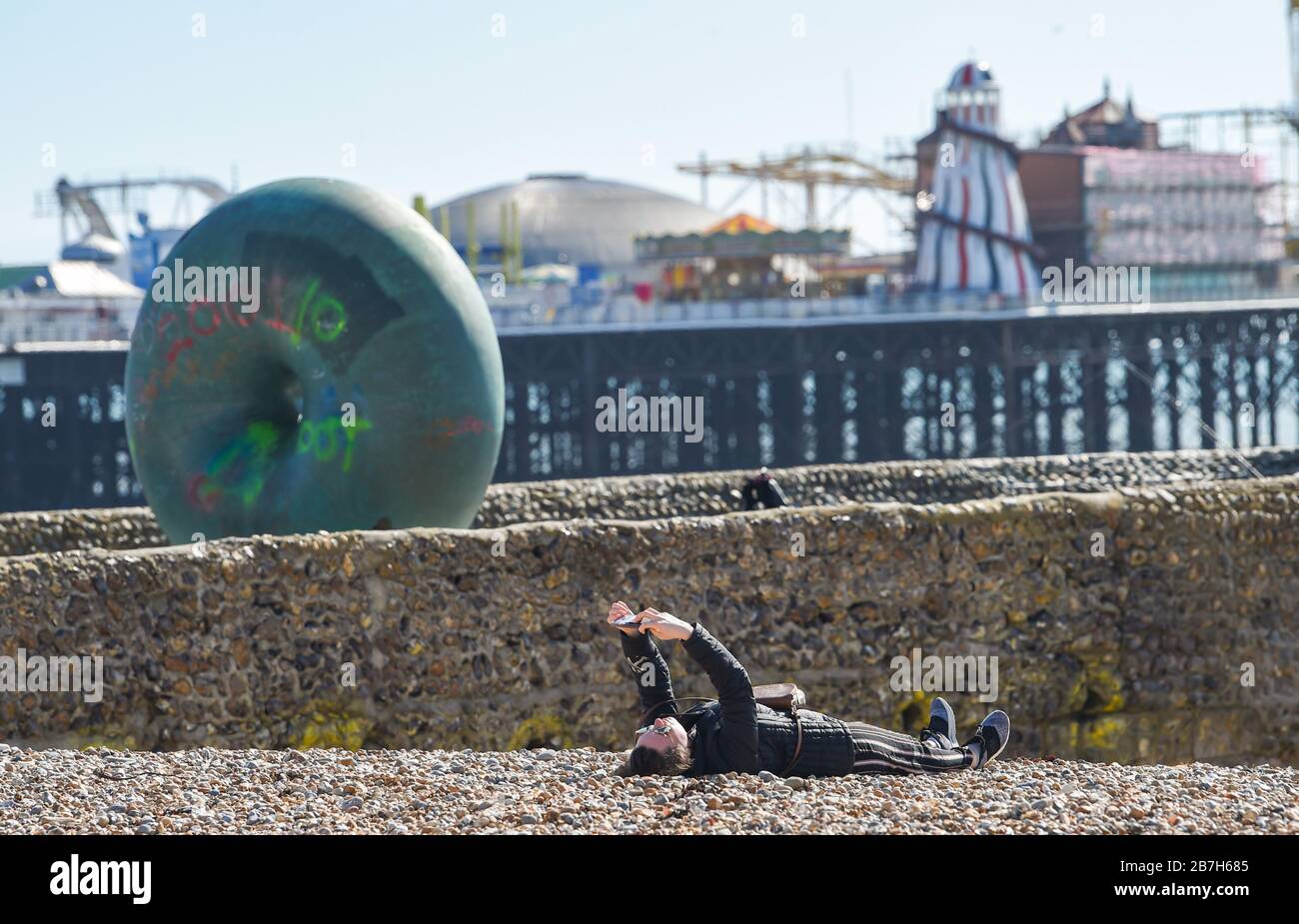 Brighton UK, 16. März 2020 - ein Besucher genießt ein Sonnenbaden am Brighton Beach an einem strahlend klaren Tag, da für die nächsten Tage in Großbritannien trockenes Wetter prognostiziert wird: Credit Simon Dack/Alamy Live News Stockfoto