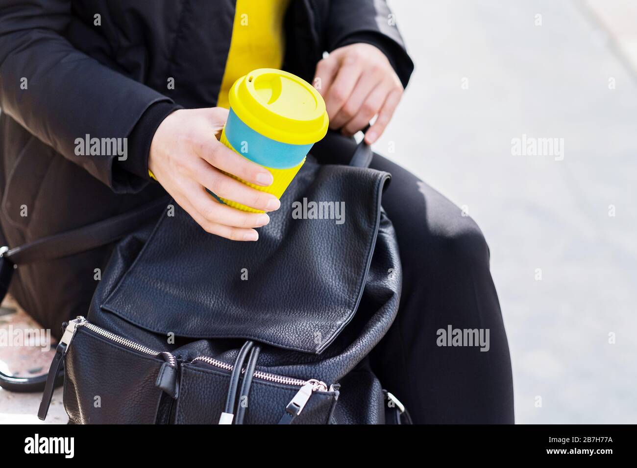 Weibliche Hände halten wiederverwendbaren Kaffeebecher. Nehmen Sie Ihren Kaffee mit einem wiederverwendbaren Becher für unterwegs. Stockfoto