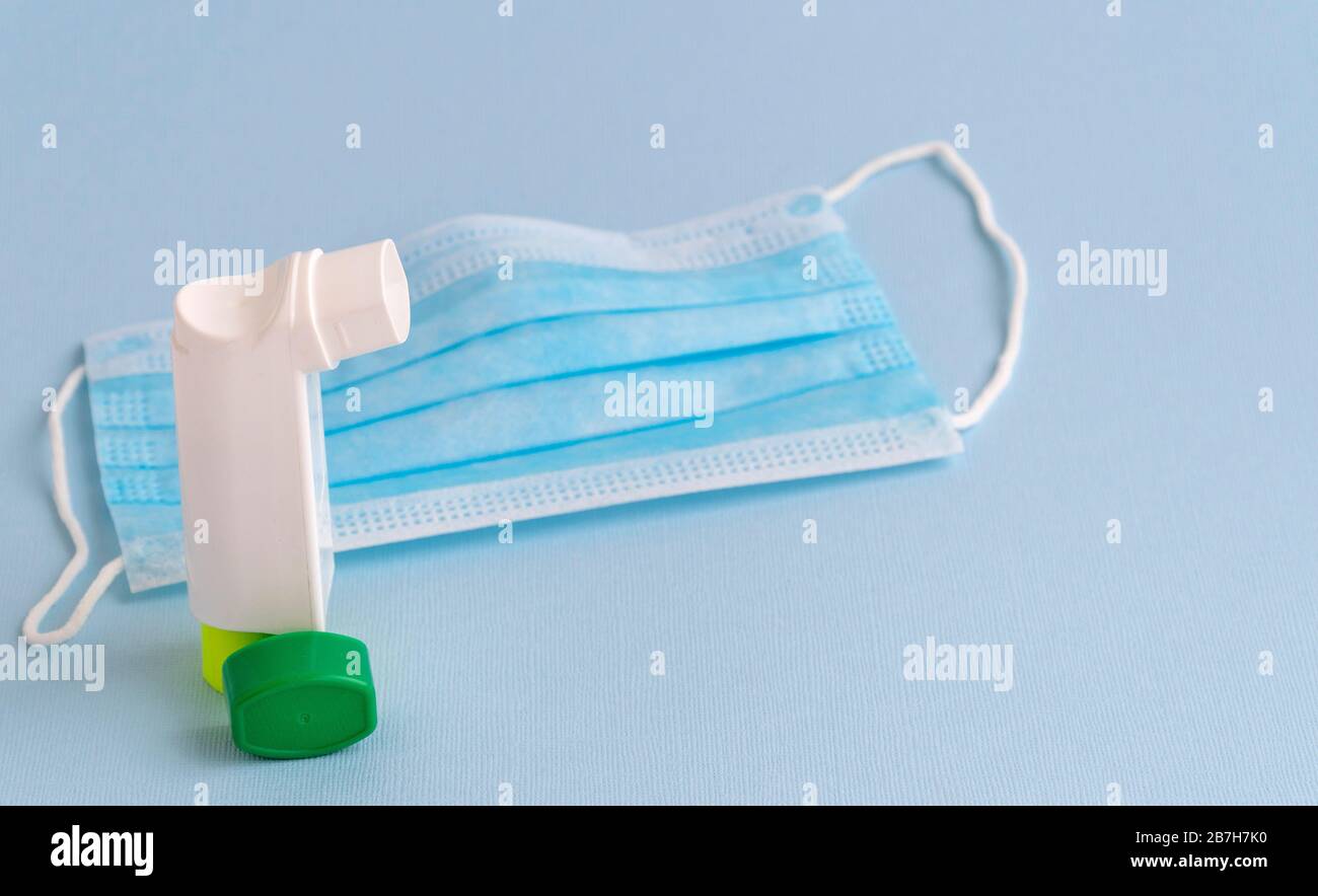Inhalator und medizinische Maske. Chirurgische Schutzmaske. Medizinischer Atemverband Gesicht und Inhalator auf blauem Hintergrund. Stockfoto
