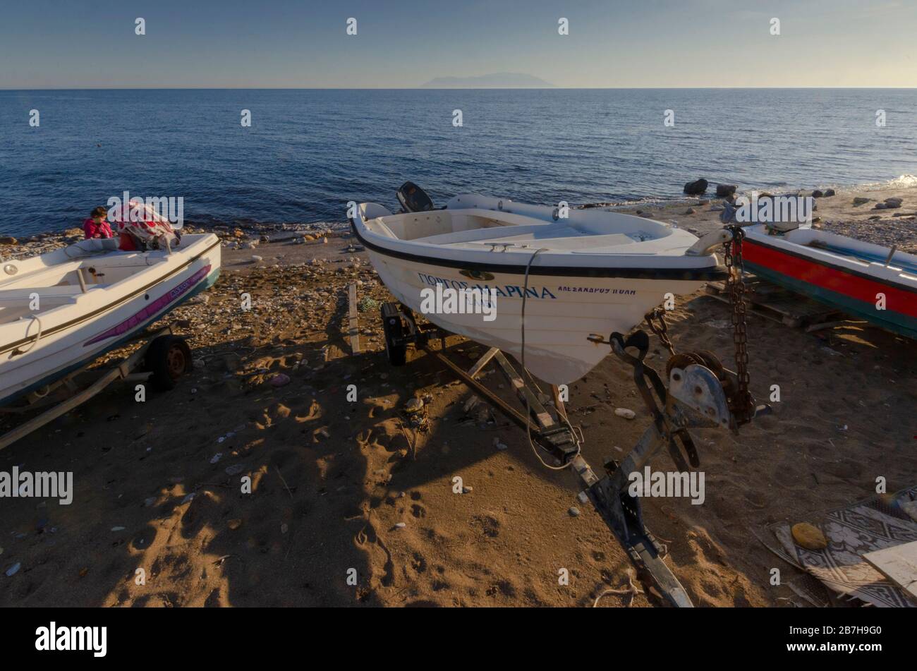 Seescape mit kleinen Küstenfischern an einem Strand von Alexandroupoli im Vordergrund und der nordgriechischen Insel Samothraki im Hintergrund Stockfoto