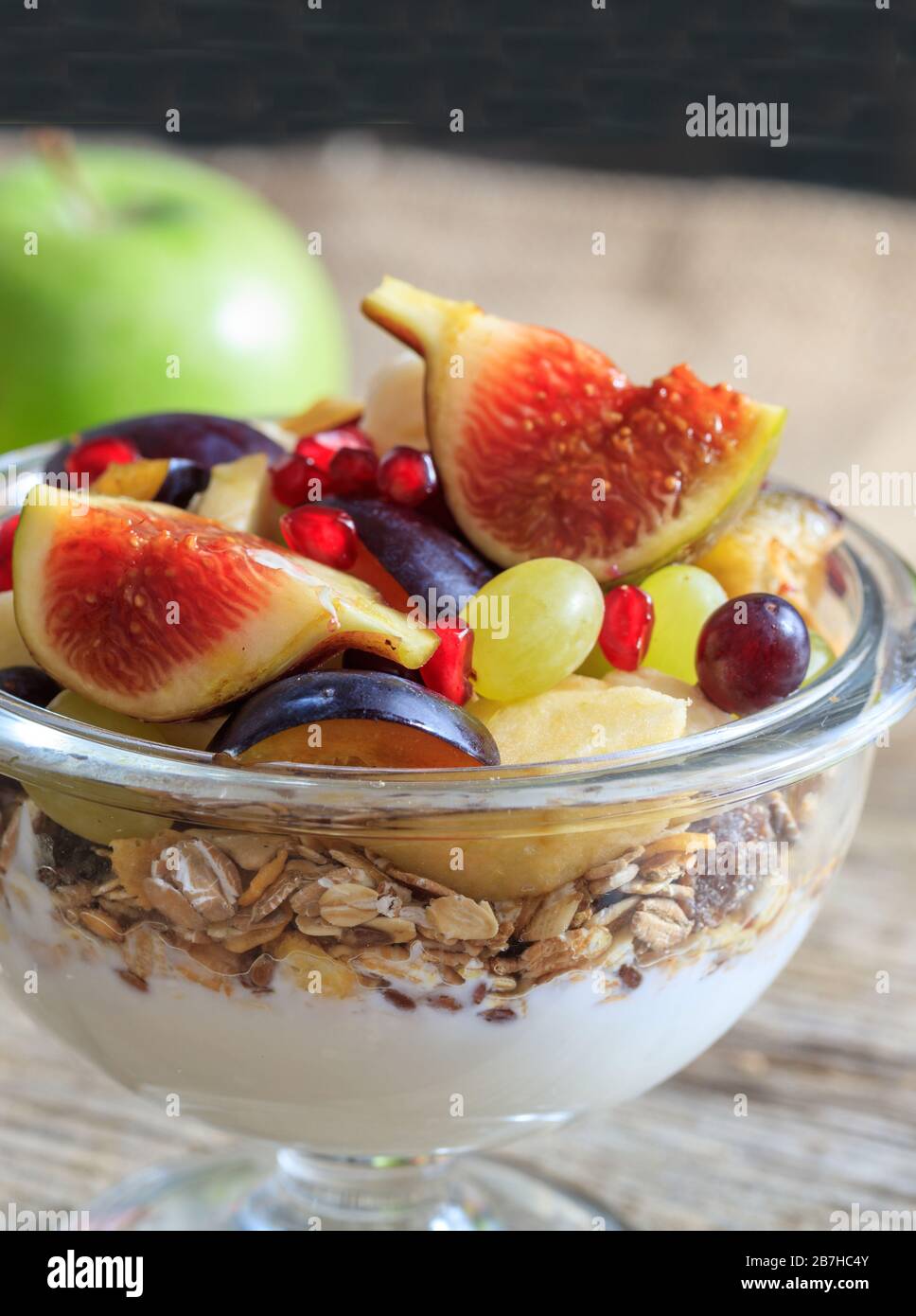 Gesundes Frühstückskonzept. Joghurt, Müsli und frisches Obst in einer Schüssel, verwischen den Hintergrund. Nahaufnahme von Lebensmitteln für einen gesunden Lebensstil. Stockfoto