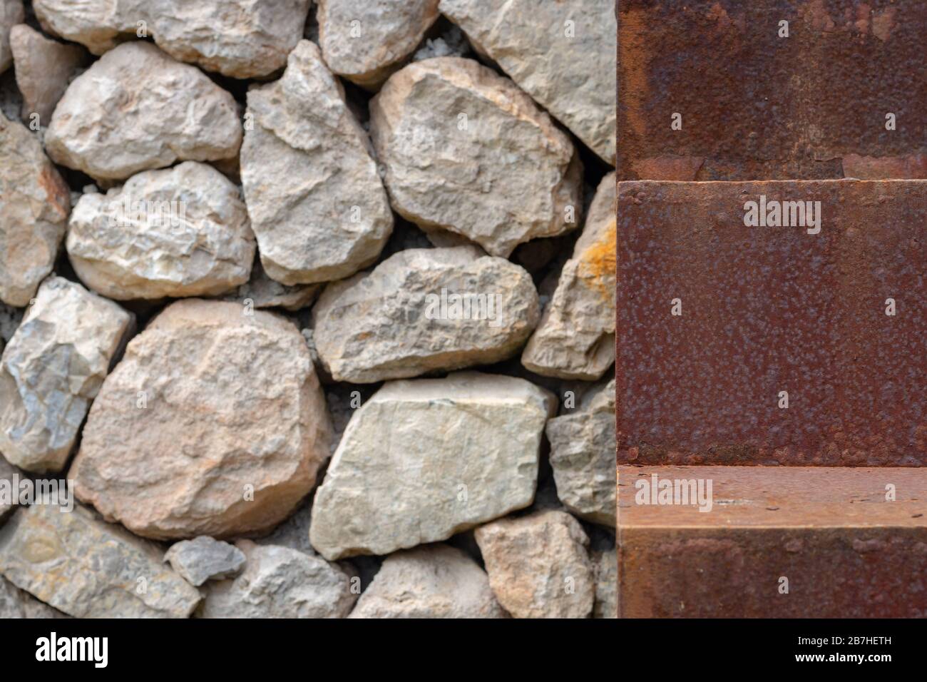 Nahaufnahme eines rostigen Schrittes einer Treppe neben einer Steinmauer Stockfoto